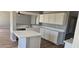 The open kitchen features white cabinets and an island with white countertops at 1876 N Parkside Ln, Casa Grande, AZ 85122