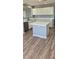 Well-lit kitchen boasts a central island, white cabinets, and durable wood-look flooring at 1876 N Parkside Ln, Casa Grande, AZ 85122