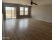 Open-concept living room with wood-look floors and sliding glass doors at 1876 N Parkside Ln, Casa Grande, AZ 85122