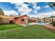 Beautiful backyard featuring an artificial lawn, pool, covered patio, and green seating area at 19645 N 3Rd Ave, Phoenix, AZ 85027