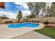 Private backyard featuring a sparkling pool with lush landscaping and a charming waterfall feature at 19645 N 3Rd Ave, Phoenix, AZ 85027