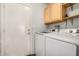 Well-lit laundry room featuring modern appliances and convenient overhead cabinet space at 19645 N 3Rd Ave, Phoenix, AZ 85027