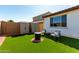 Relaxing backyard area features artificial grass, two storage sheds, and cozy seating around a fire pit at 21056 W Granada Rd, Buckeye, AZ 85396