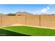 Expansive backyard featuring easy care turf grass and a block wall with mountain views at 21056 W Granada Rd, Buckeye, AZ 85396