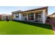 Spacious backyard with artificial grass, covered patio, and comfortable seating area for entertainment at 21056 W Granada Rd, Buckeye, AZ 85396