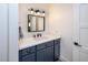 Modern bathroom features navy blue vanity with black hardware and framed mirror at 2146 W Isabella Ave # 154, Mesa, AZ 85202