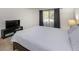 Serene bedroom features carpet, a TV, and a large window with dark curtains at 2146 W Isabella Ave # 154, Mesa, AZ 85202