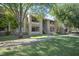 Exterior view of a multi-story apartment building with well manicured green space and mature trees at 2146 W Isabella Ave # 154, Mesa, AZ 85202