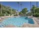 Sparkling community pool with lounge chairs, surrounded by lush landscaping and mature trees at 2146 W Isabella Ave # 154, Mesa, AZ 85202