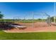 Fenced baseball field featuring bleachers, a well-maintained infield, and a green outfield perfect for sporting events at 21882 N 260Th Ln, Buckeye, AZ 85396