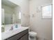 Well-lit bathroom featuring a large mirror, vanity with sink, and toilet at 21882 N 260Th Ln, Buckeye, AZ 85396