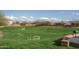 Well-maintained community park with lush green lawn, benches, mature trees, and BBQ area for residents at 21882 N 260Th Ln, Buckeye, AZ 85396