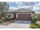 Charming home exterior with tile roof, desert landscaping, and two car garage at 21882 N 260Th Ln, Buckeye, AZ 85396