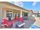 Rear covered patio featuring brick flooring, comfortable seating, and a fire pit at 2380 E Seville Ct, Casa Grande, AZ 85194