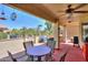 View of covered patio with ceiling fan, outdoor furniture and beautifully landscaped backyard and bird feeders at 2380 E Seville Ct, Casa Grande, AZ 85194