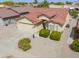 Exterior view of a tan stucco home featuring a red tile roof, a two-car garage, and desert landscaping at 2380 E Seville Ct, Casa Grande, AZ 85194
