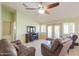 Open living room with a ceiling fan, fireplace, and access to the patio through glass doors at 2380 E Seville Ct, Casa Grande, AZ 85194