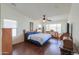 Bright main bedroom featuring wood-look flooring, a ceiling fan and dual pane windows at 2380 E Seville Ct, Casa Grande, AZ 85194
