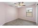 Comfortable bedroom features a ceiling fan, carpet, and a window overlooking the side yard at 2523 W Running Deer Trl, Phoenix, AZ 85085