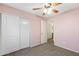 Bedroom features closet, pink walls, carpet, and ceiling fan at 2523 W Running Deer Trl, Phoenix, AZ 85085
