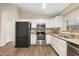 Stylish kitchen with stainless steel appliances, granite countertops, white cabinets, and wood-look floors at 2523 W Running Deer Trl, Phoenix, AZ 85085