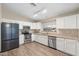 Well-lit kitchen showcasing stainless steel appliances, light countertops, and wood-look flooring at 2523 W Running Deer Trl, Phoenix, AZ 85085