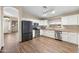 Modern kitchen with stainless steel appliances, white cabinets, granite countertops, and wood-look floors at 2523 W Running Deer Trl, Phoenix, AZ 85085