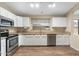 Well-lit kitchen featuring white cabinets, stainless steel appliances, granite countertops, and wood-look floors at 2523 W Running Deer Trl, Phoenix, AZ 85085