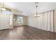 Bright, neutral living room showcasing wood-look floors, plenty of natural light, and updated lighting fixture at 2523 W Running Deer Trl, Phoenix, AZ 85085