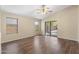 Spacious living room with wood-look flooring, fan, and sliding glass door to backyard at 2523 W Running Deer Trl, Phoenix, AZ 85085