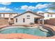 Backyard view of a private pool with a red concrete border, surrounded by an easy to maintain gravel yard and a covered patio at 2523 W Running Deer Trl, Phoenix, AZ 85085