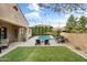Beautifully landscaped backyard with a refreshing pool, cozy lounge area, and lush green synthetic turf at 2664 E Ebony Dr, Chandler, AZ 85286