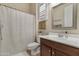 Cozy bathroom featuring a shower with a curtain, a white vanity, a framed mirror, and natural lighting at 2664 E Ebony Dr, Chandler, AZ 85286