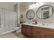 Well-lit bathroom featuring dual sinks with elegant mirrors and a shower-tub combination at 2664 E Ebony Dr, Chandler, AZ 85286