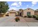 Beautiful exterior view of a desert home with a three-car garage, paver driveway, and manicured landscaping at 2664 E Ebony Dr, Chandler, AZ 85286