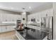 Bright kitchen featuring white cabinets, black countertops, stainless steel appliances, and a kitchen island at 2664 E Ebony Dr, Chandler, AZ 85286