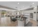 Open concept kitchen with stainless steel appliances, island with sink and black countertop, and a dining area with a decorative light fixture at 2664 E Ebony Dr, Chandler, AZ 85286
