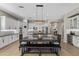 Bright kitchen with white cabinets, black countertops, an island, stainless steel appliances, and decorative chandelier at 2664 E Ebony Dr, Chandler, AZ 85286