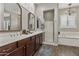 Elegant main bathroom featuring dual sinks, a glass-enclosed shower, and a freestanding soaking tub at 2664 E Ebony Dr, Chandler, AZ 85286