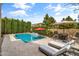 Stunning pool area with travertine tile, modern lounge furniture, and lush privacy landscaping at 2664 E Ebony Dr, Chandler, AZ 85286