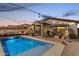 Inviting backyard with a sparkling pool and covered patio at dusk at 3219 W Pollack St, Phoenix, AZ 85041