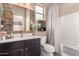 Well-lit bathroom featuring a dark vanity, white bathtub, stained-glass window, and neutral color scheme at 3219 W Pollack St, Phoenix, AZ 85041