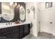 Modern bathroom featuring double vanity with black cabinets, decorative mirrors, and trendy black and white hexagon tile accent wall at 3219 W Pollack St, Phoenix, AZ 85041