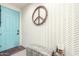Bright entryway featuring a trendy blue door, stylish wallpaper, and a decorative peace sign wreath at 3219 W Pollack St, Phoenix, AZ 85041