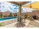 Covered patio area featuring table and chairs overlooking a shimmering pool at 3219 W Pollack St, Phoenix, AZ 85041
