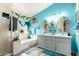 Bright bathroom with a large tub, walk-in shower, dual vanities, and blue accent wall at 3708 S 104Th Ln, Tolleson, AZ 85353