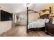 Spacious bedroom featuring a four-poster bed, hardwood floors and a window seat with natural light at 3708 S 104Th Ln, Tolleson, AZ 85353