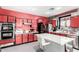 Modern kitchen with red cabinetry, a sleek island, and stainless-steel appliances, offering ample counter space at 3708 S 104Th Ln, Tolleson, AZ 85353