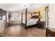 Inviting main bedroom featuring a four-poster bed, hardwood floors, and a cozy window seat at 3708 S 104Th Ln, Tolleson, AZ 85353