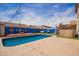 Inviting backyard pool area with bright blue accent fence, and stylish lighting, perfect for outdoor entertaining at 3708 S 104Th Ln, Tolleson, AZ 85353